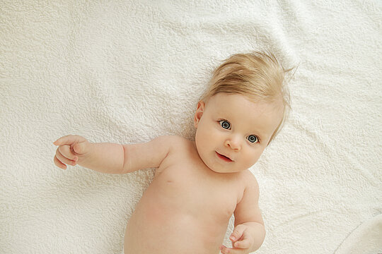 Afbeelding van een baby die op bed ligt