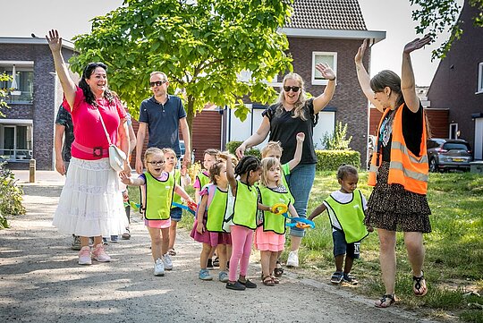 Foto met kinderen en begeleiders die aan het wandelen zijn.