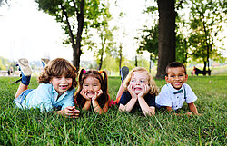 friends of preschool kids playing lying on the grass in the Park on a summer day